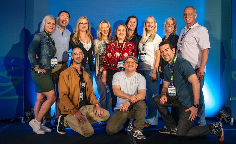Twelve course students posing together on stage at the Sellers Summit conference